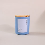 Blue soy wax candle with wooden lid and white label on neutral background